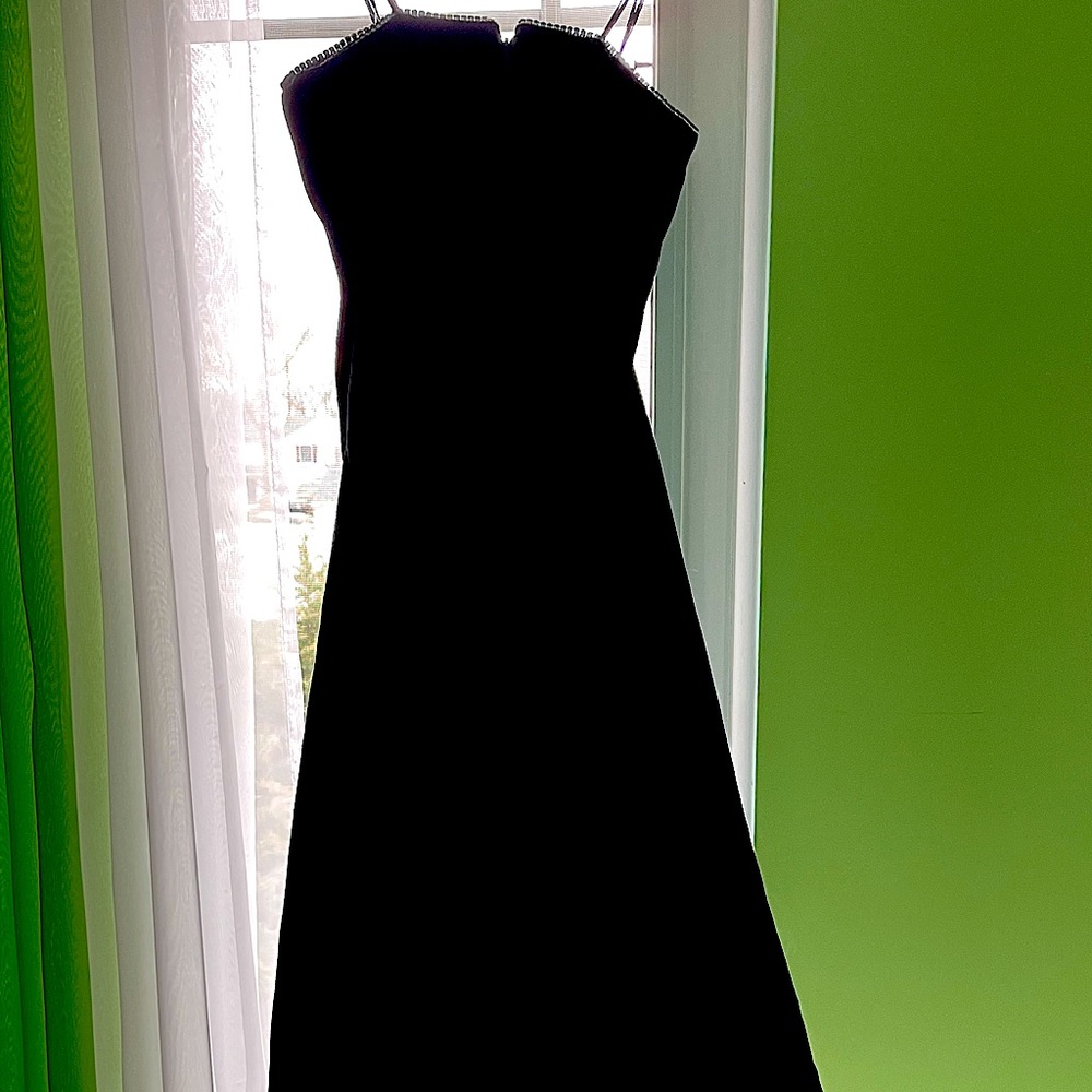 Strapless black velvet formal dress with rhinestone trim at border of bodice.